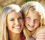 Mom and young daughter smiling